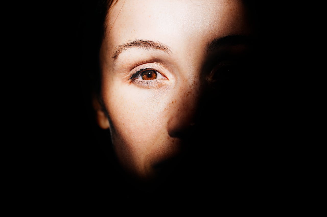 Close-up of a face half in shadow symbolizing trauma and healing through EMDR therapy